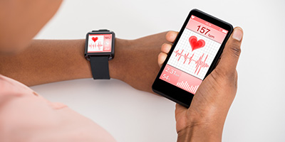 a person holds a phone showing a health app connected to a smart watch